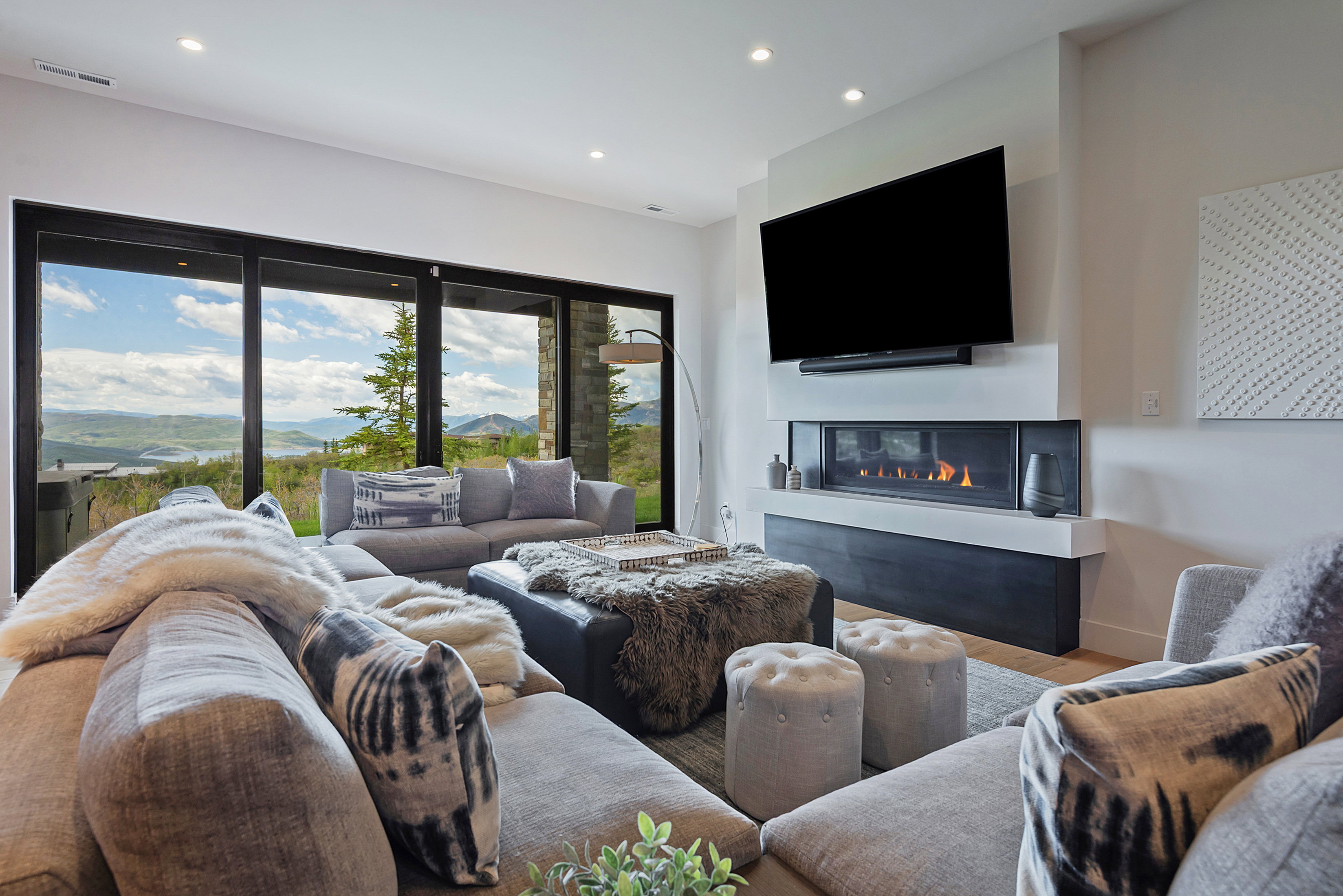 Living area with expansive sliding glass doors showcasing distant mountains and a body of water