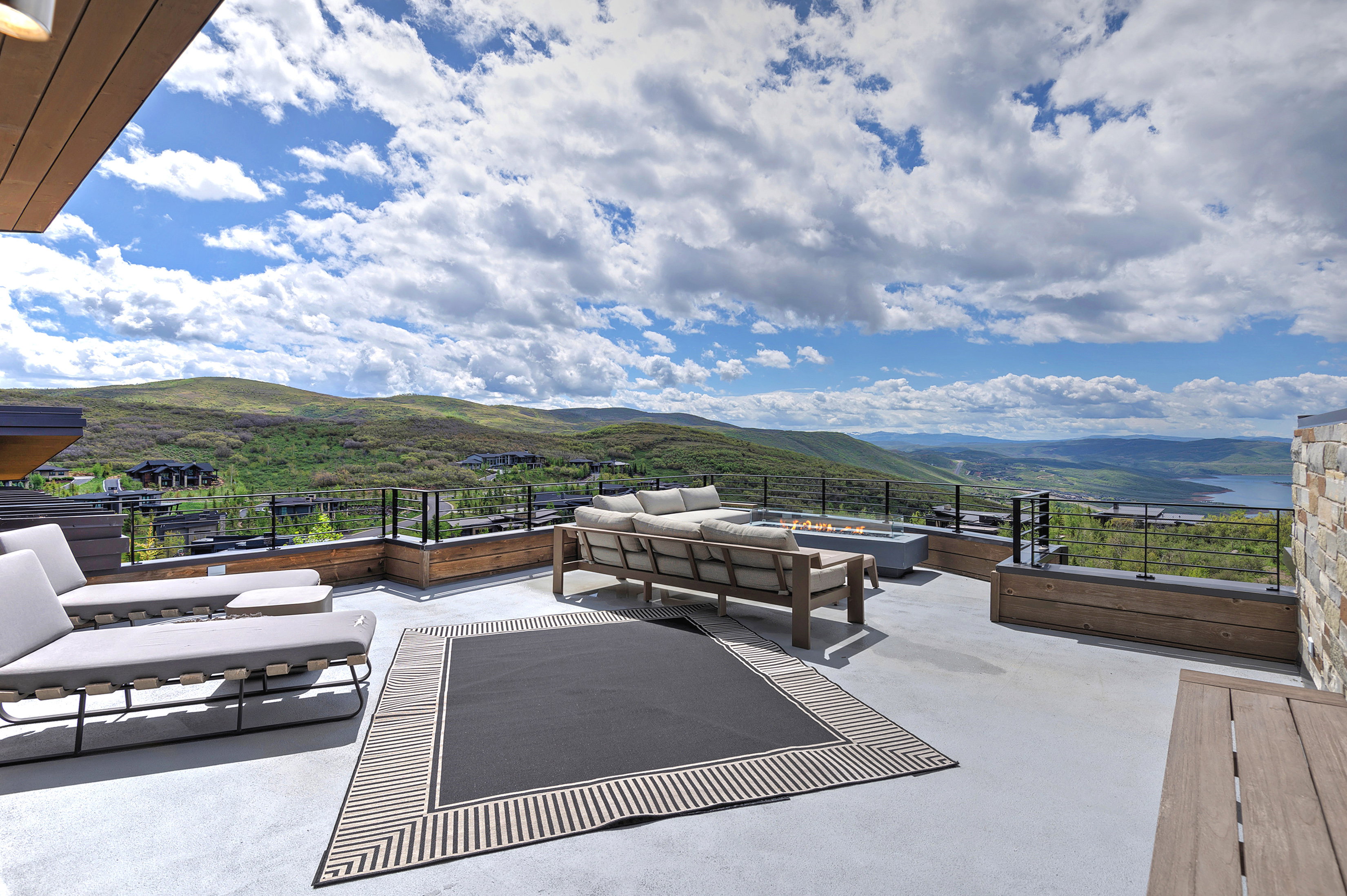 Expansive outdoor deck featuring a concrete surface and glass-panel railings