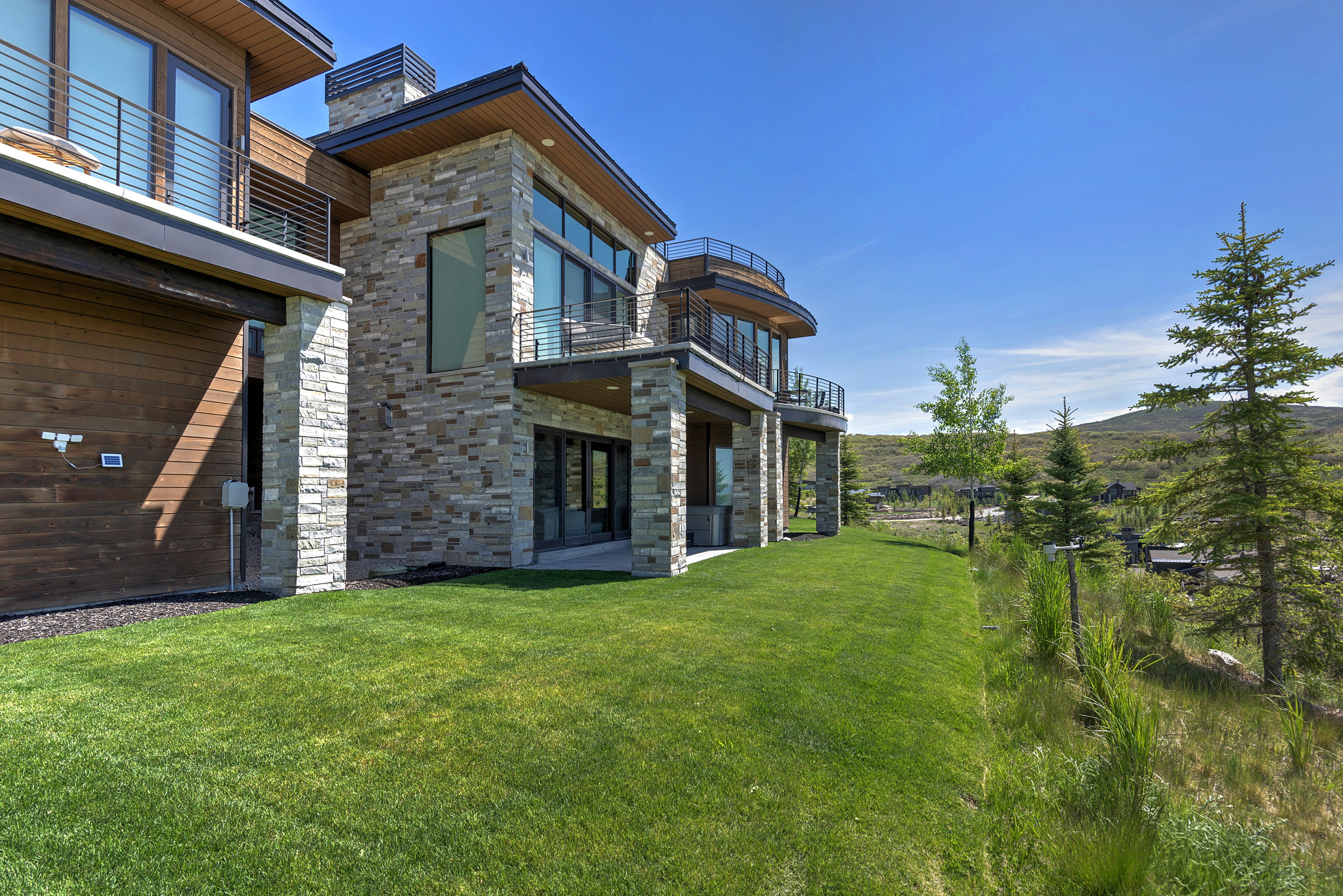 Contemporary residence featuring stone and wood-finish siding