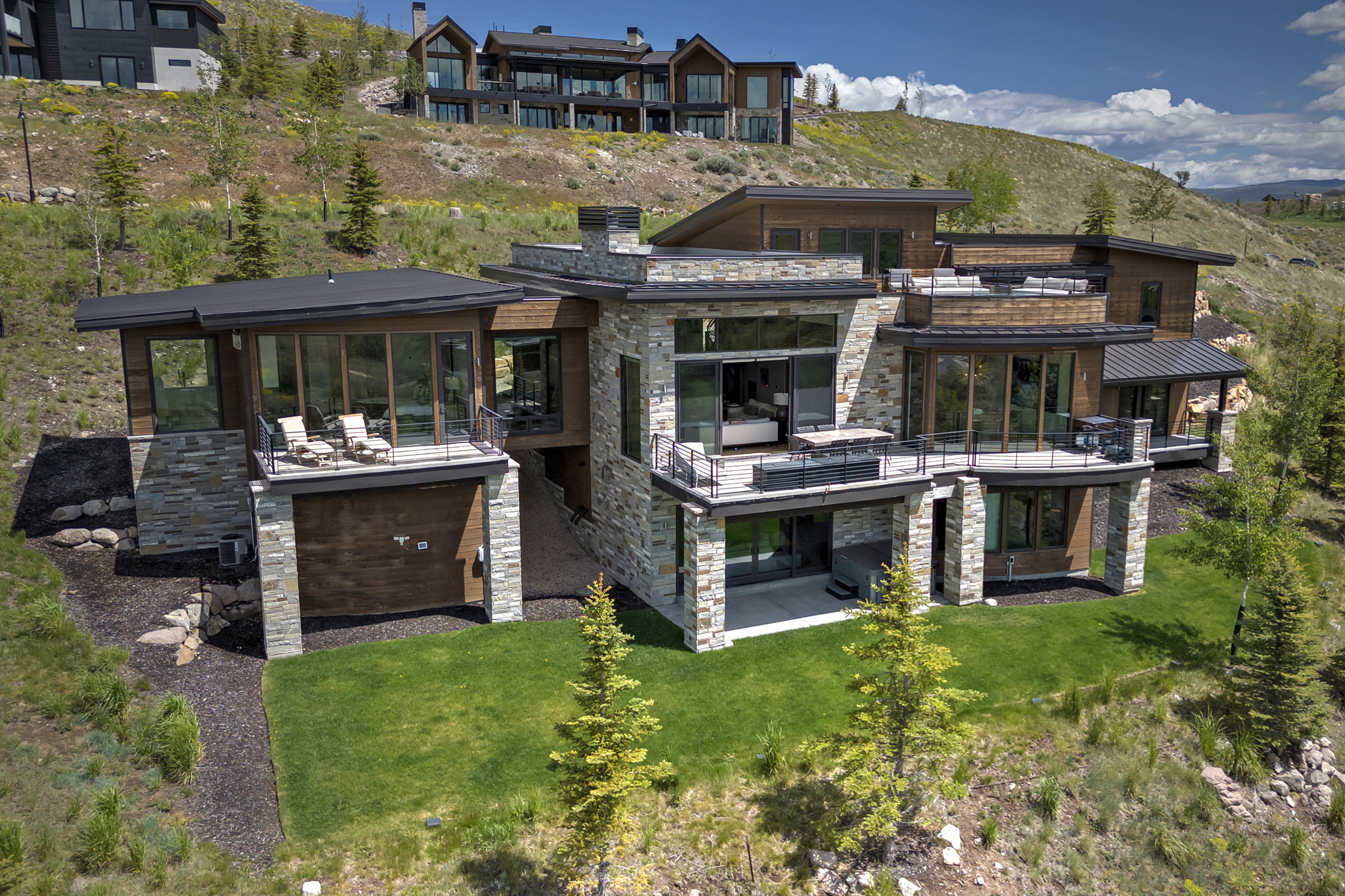 Contemporary multi-level residence featuring extensive stone and wood paneling
