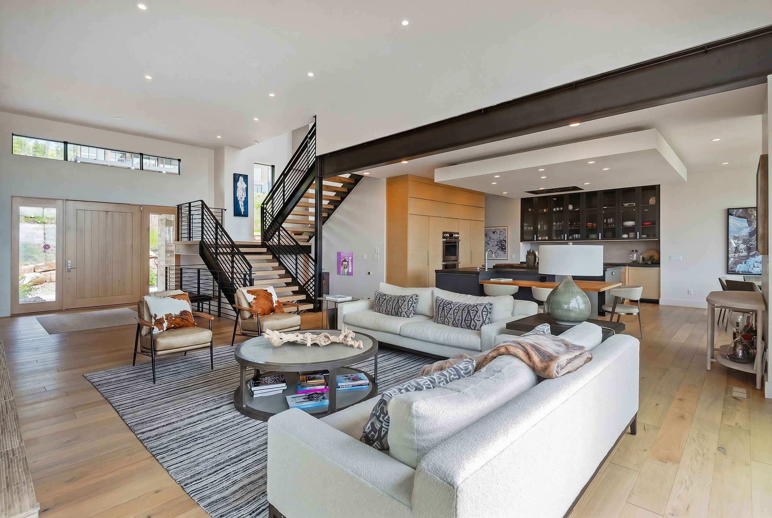 Spacious open-concept living area featuring light wood-finish flooring and recessed lighting