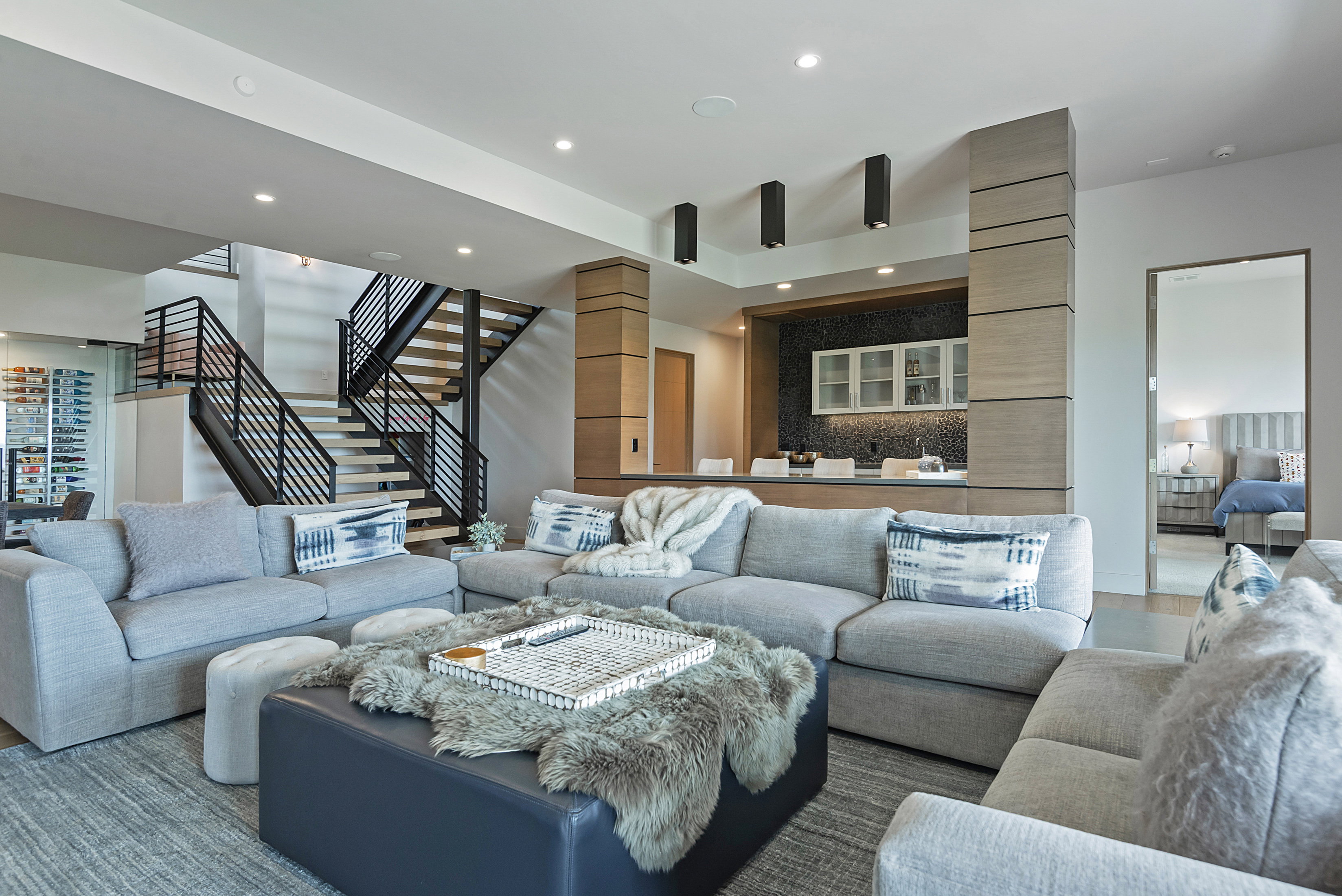 Spacious living area featuring recessed lighting, a built-in wet bar with upper cabinetry, and wood-finish flooring