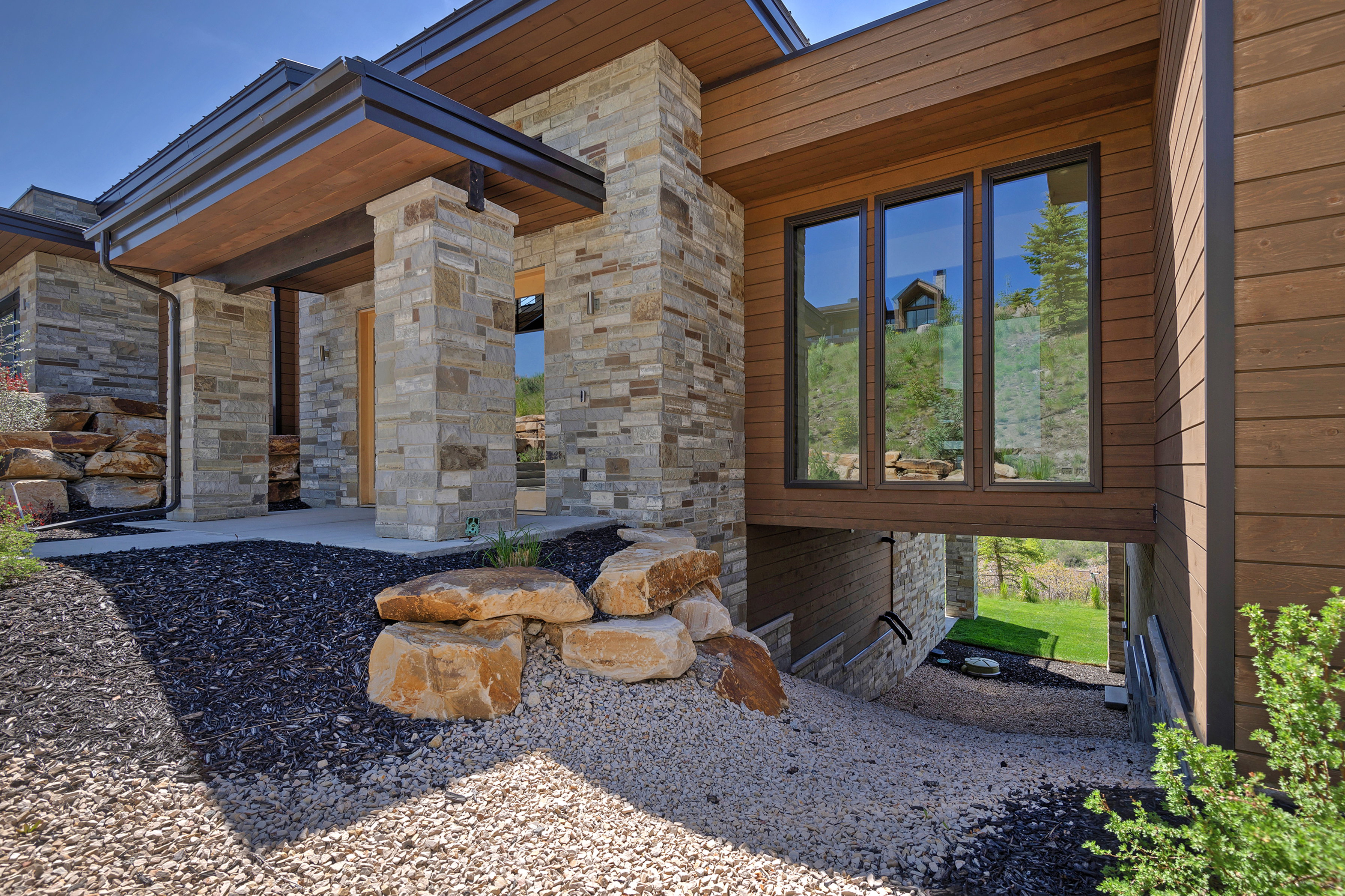 Modern facade featuring stone veneer and horizontal wood-finish siding