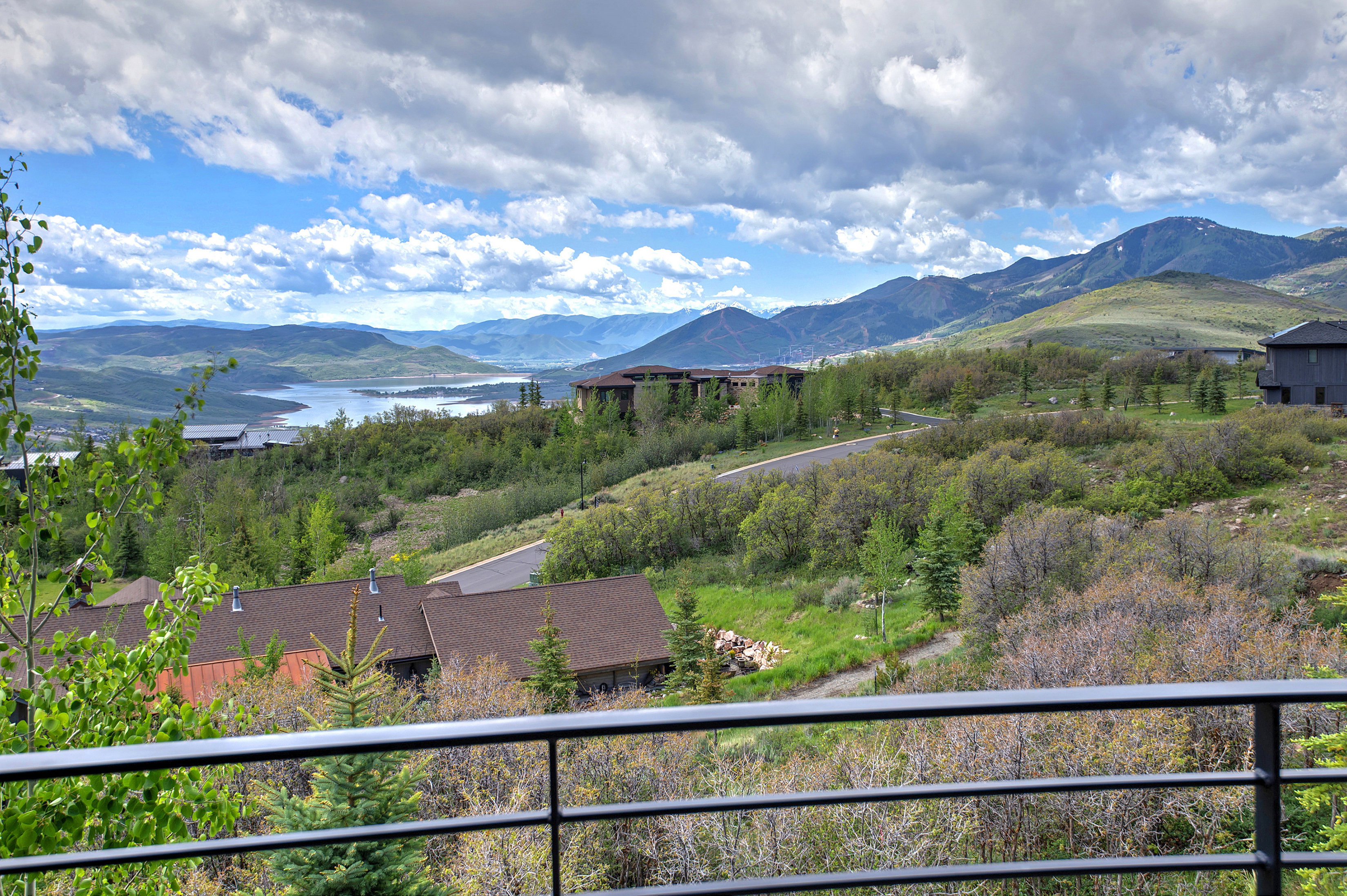 Expansive mountain landscape featuring distant lake, rolling hills, and scattered residences