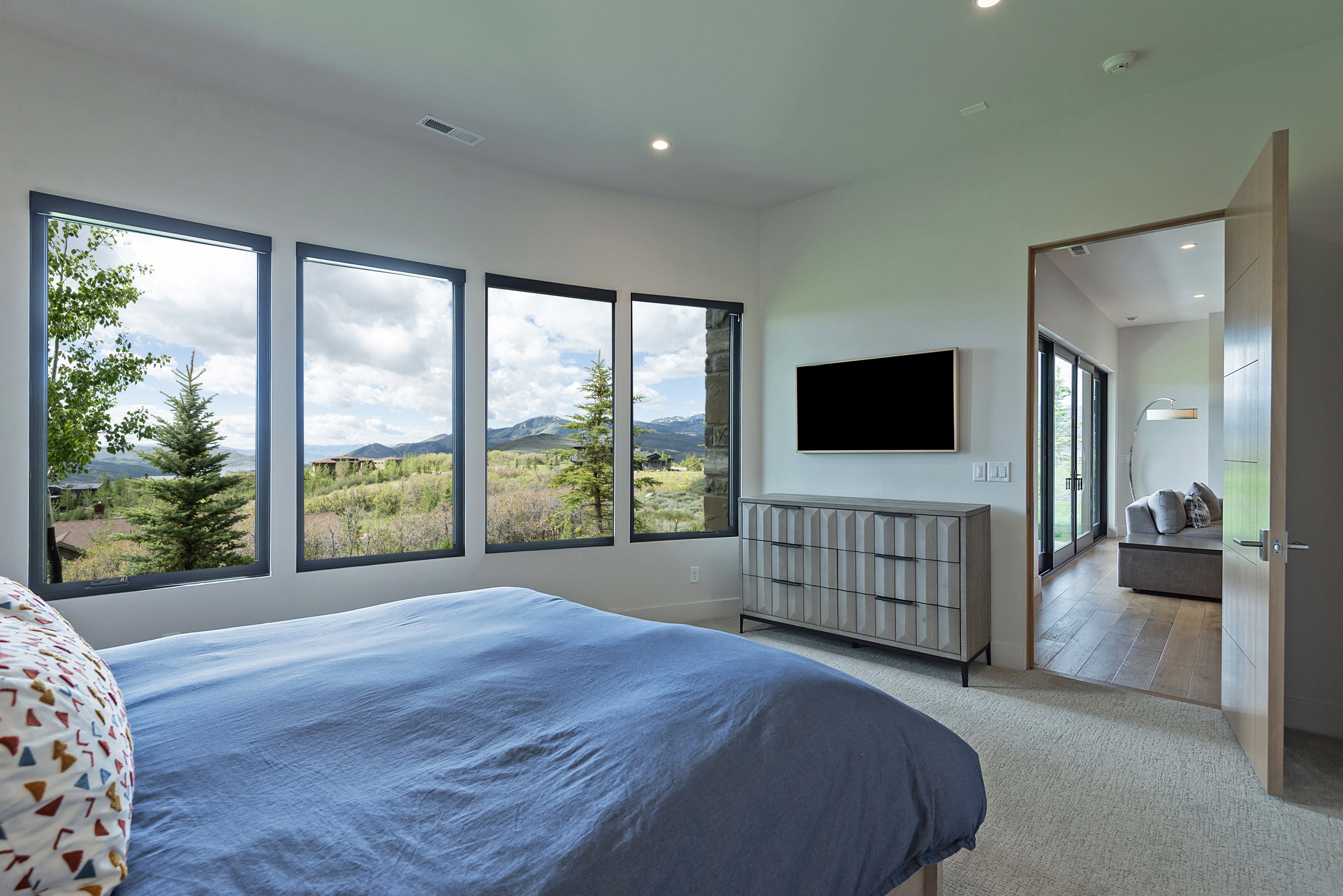 Room featuring multiple rectangular windows with dark frames, recessed ceiling lighting, and light-toned carpeting