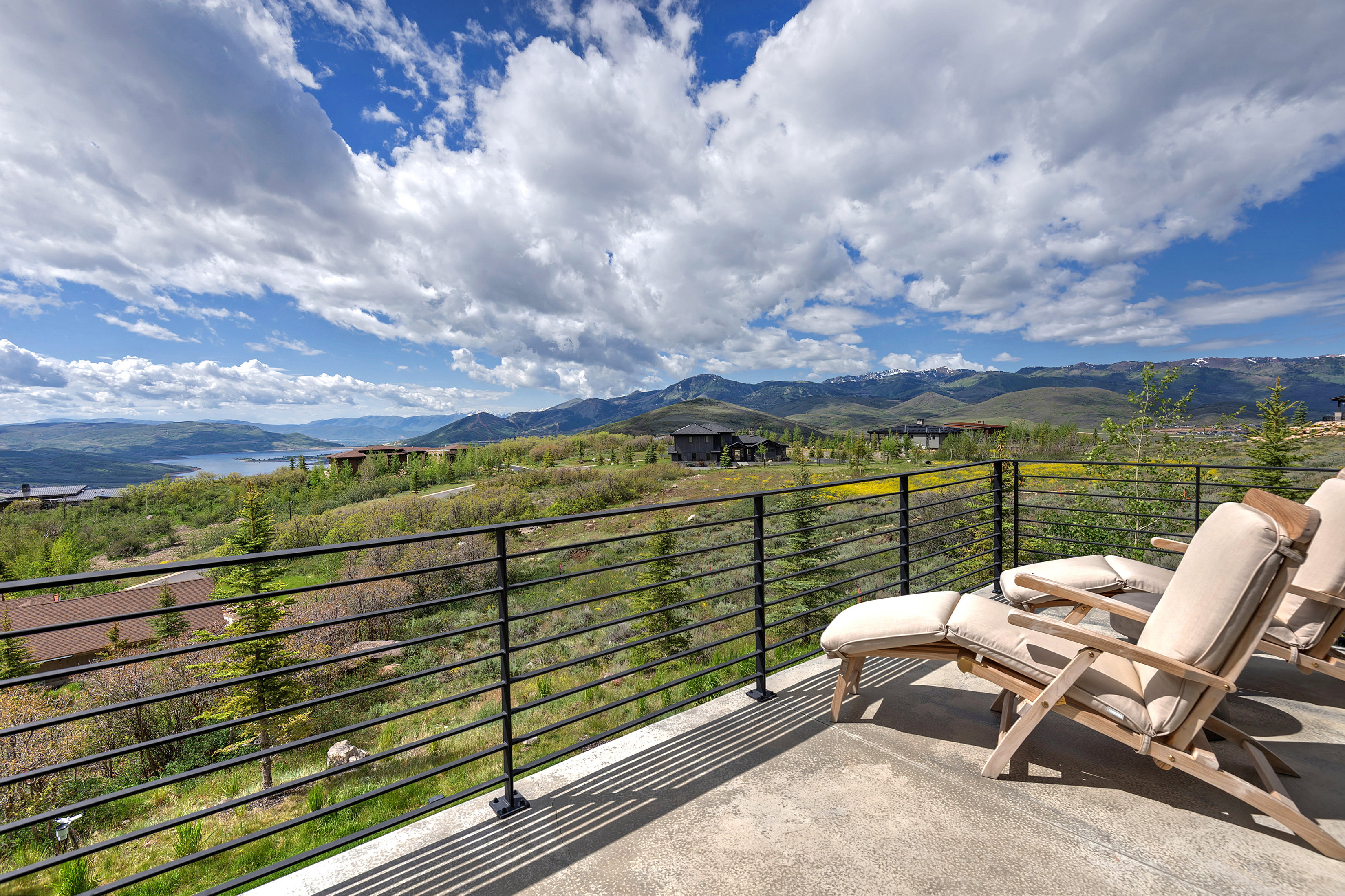 Spacious balcony featuring a concrete surface and black metal horizontal bar railing