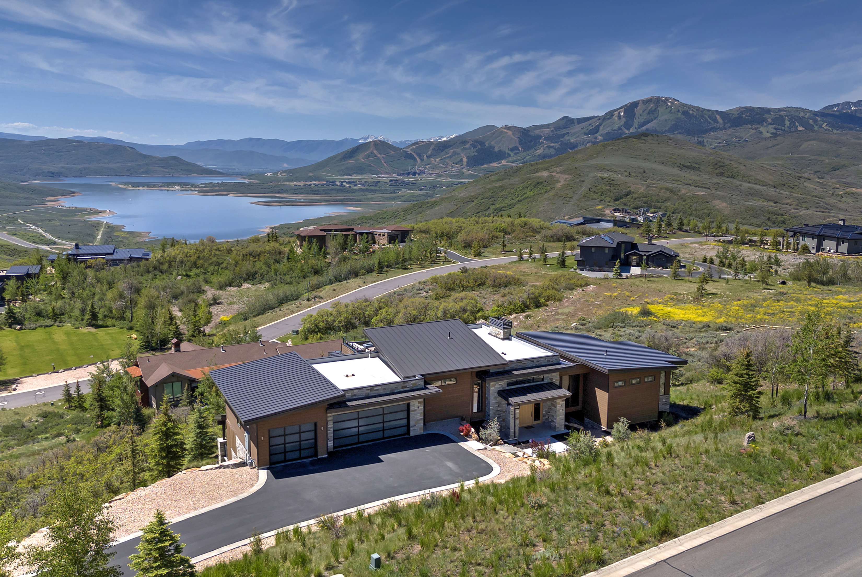 Modern architectural residence with a dark-paneled exterior and multiple garage doors