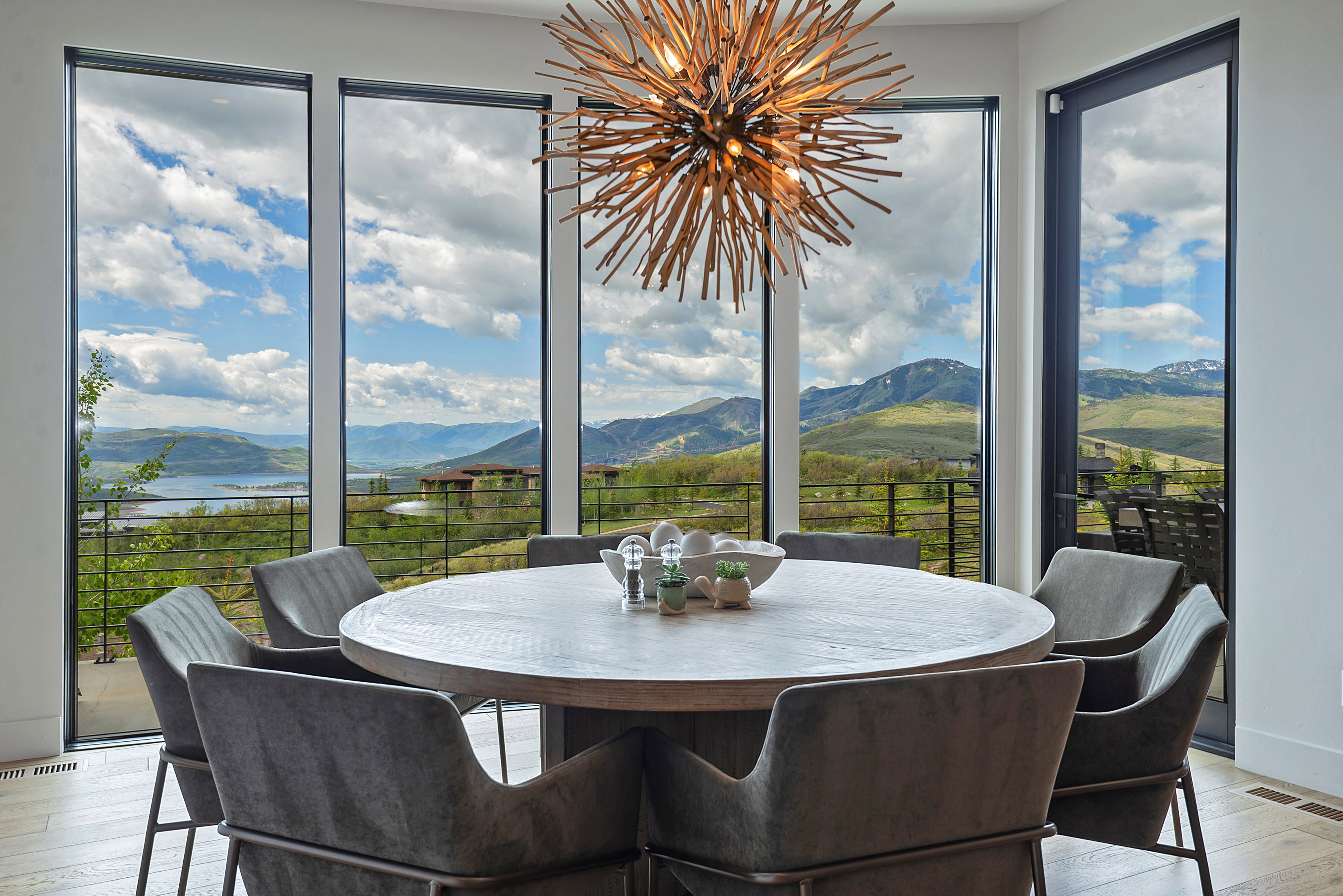 Dining area featuring floor-to-ceiling windows, a wood-finish dining table, and a contemporary chandelier
