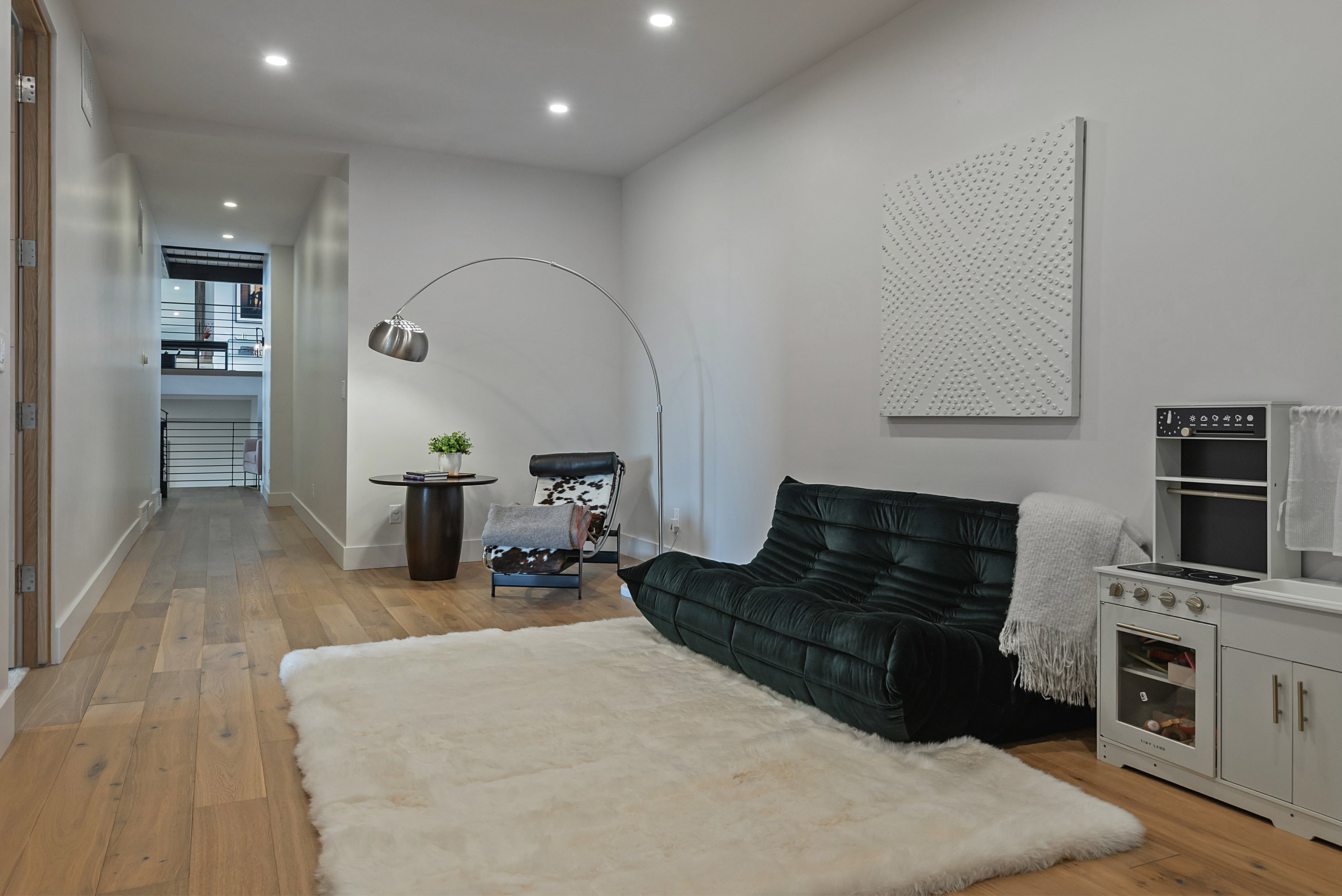Wide plank wood-finish flooring extends through a bright interior space with recessed lighting