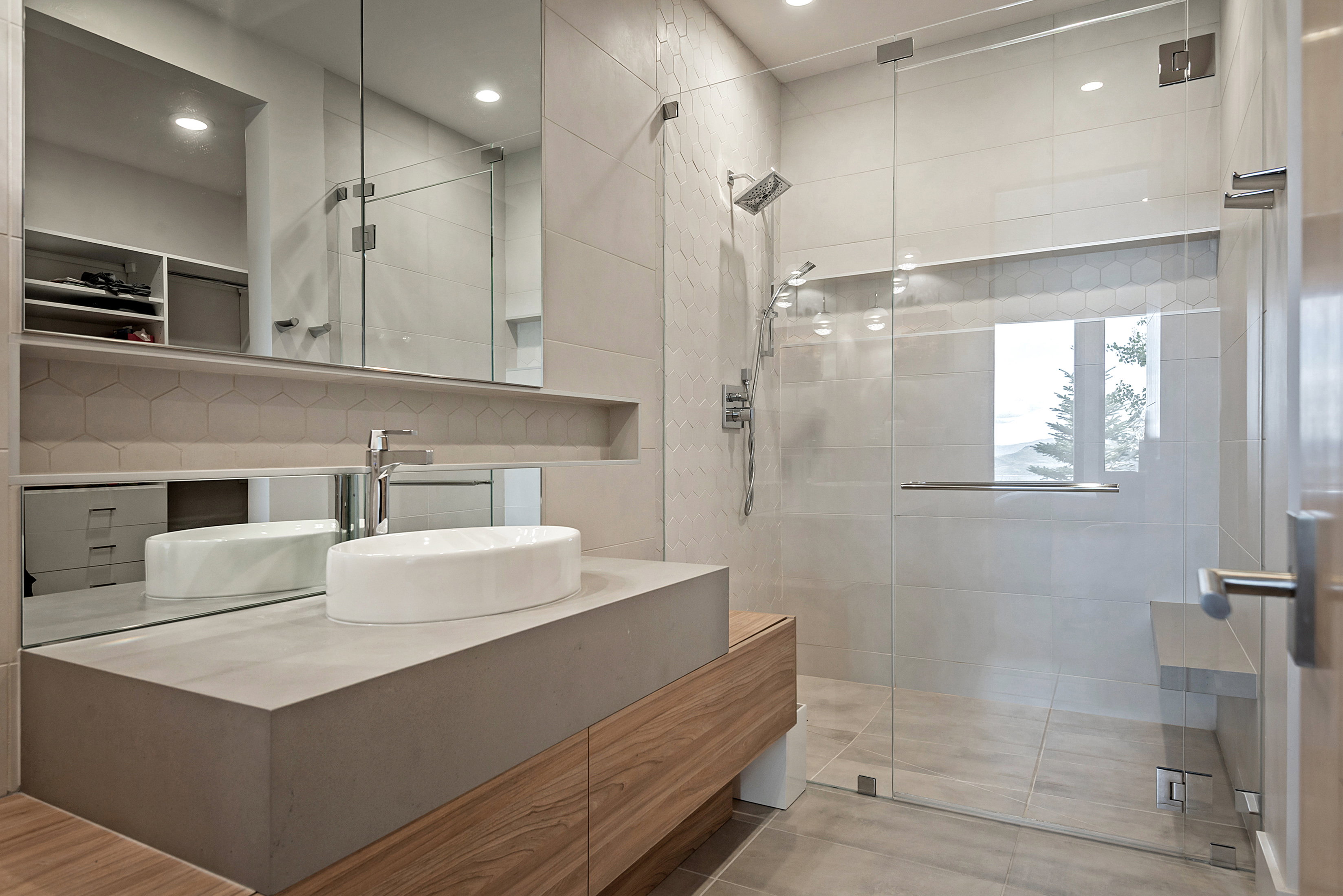 Modern bathroom with a vessel sink, wood-finish vanity, and a large mirror