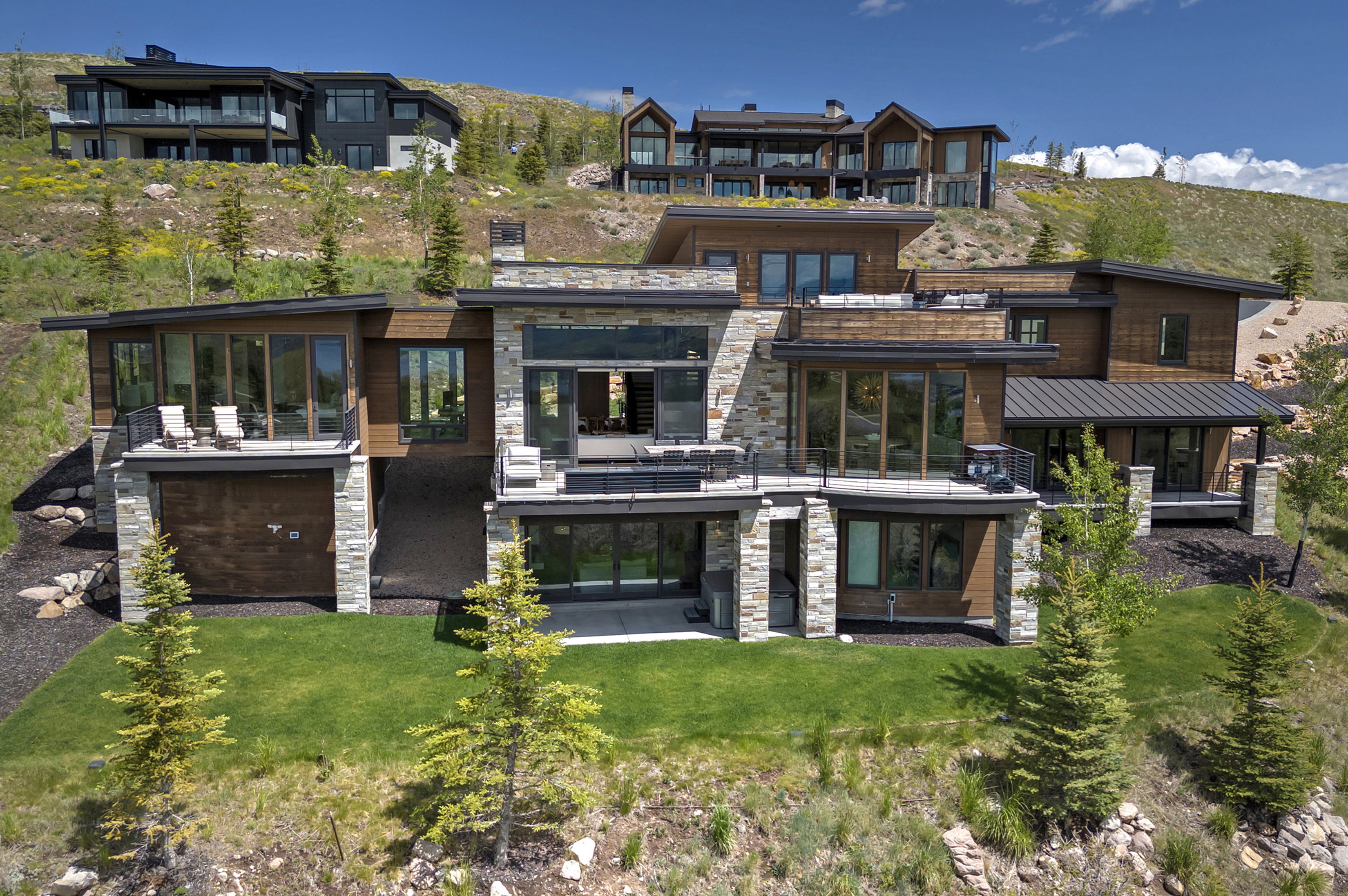 Contemporary multi-level residence featuring extensive stone and wood-panel siding