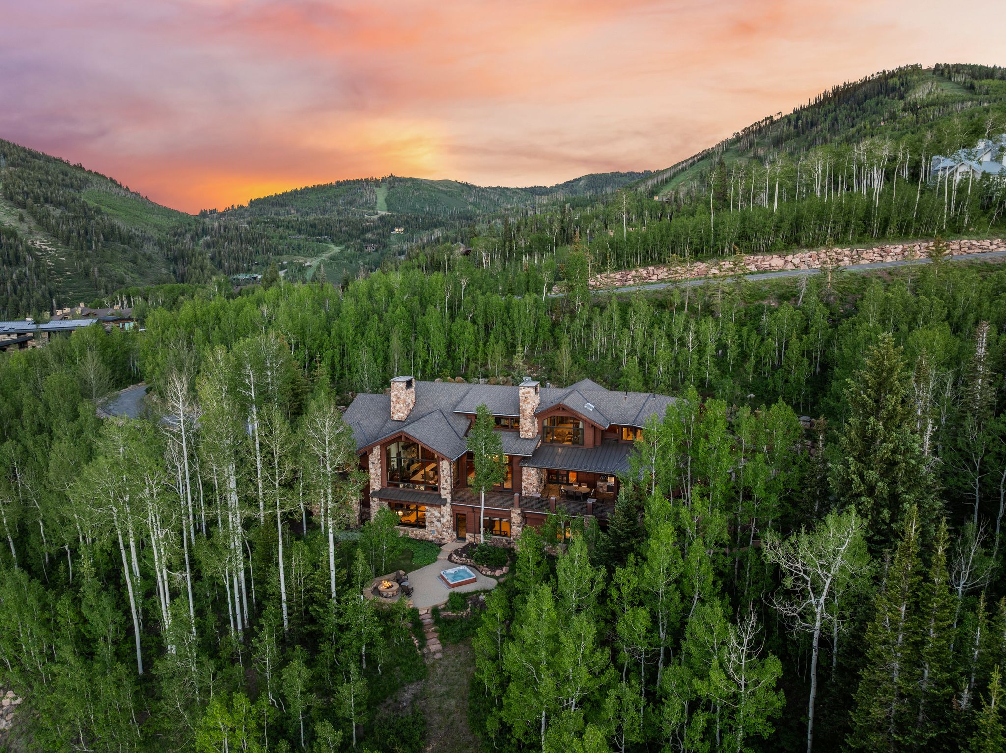 Mountain-style residence featuring a stone and wood facade with multiple gables and prominent chimneys