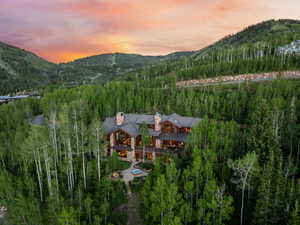 Mountain-style residence featuring a stone and wood facade with multiple gables and prominent chimneys