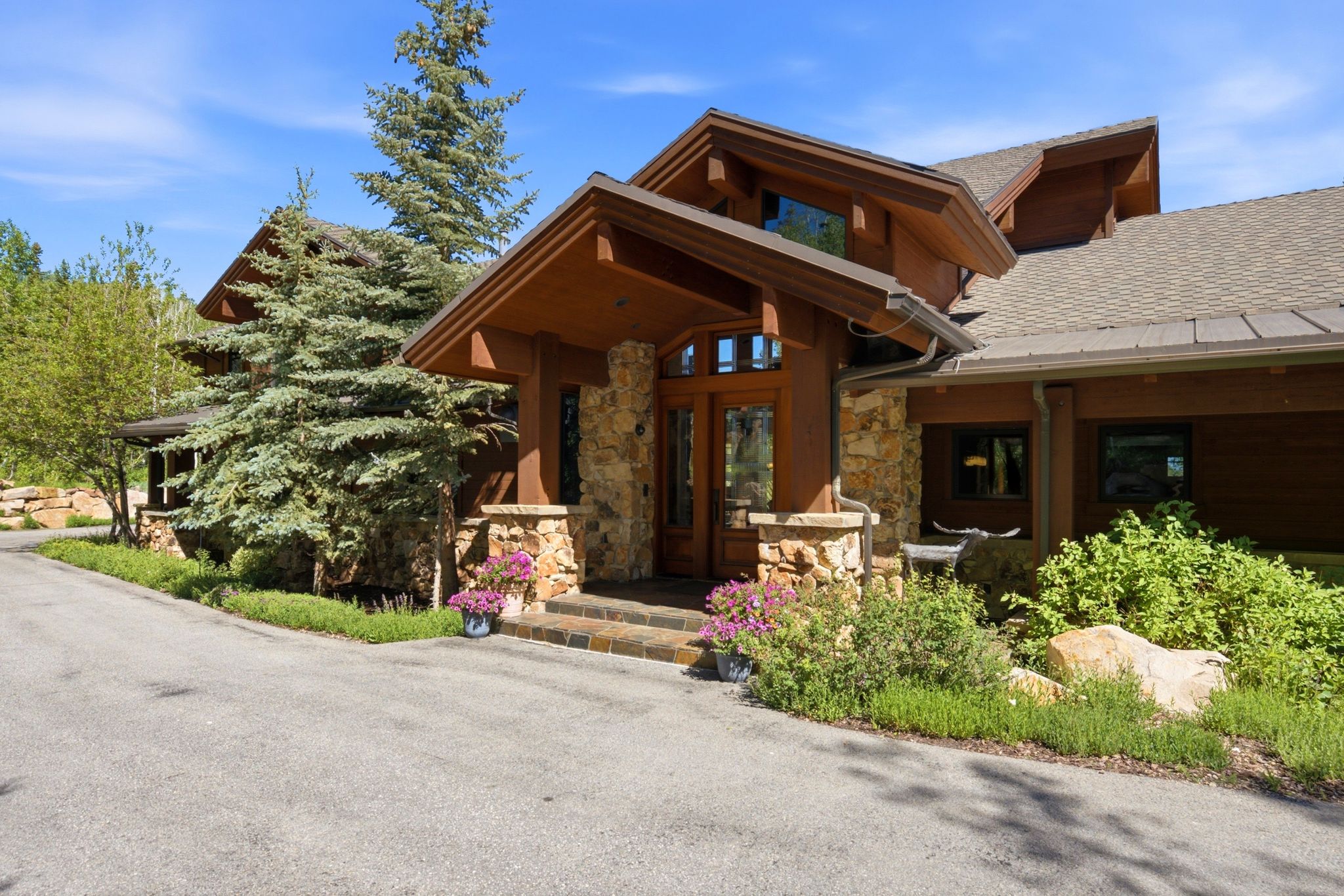 Stone and wood-clad exterior featuring a prominent covered entry