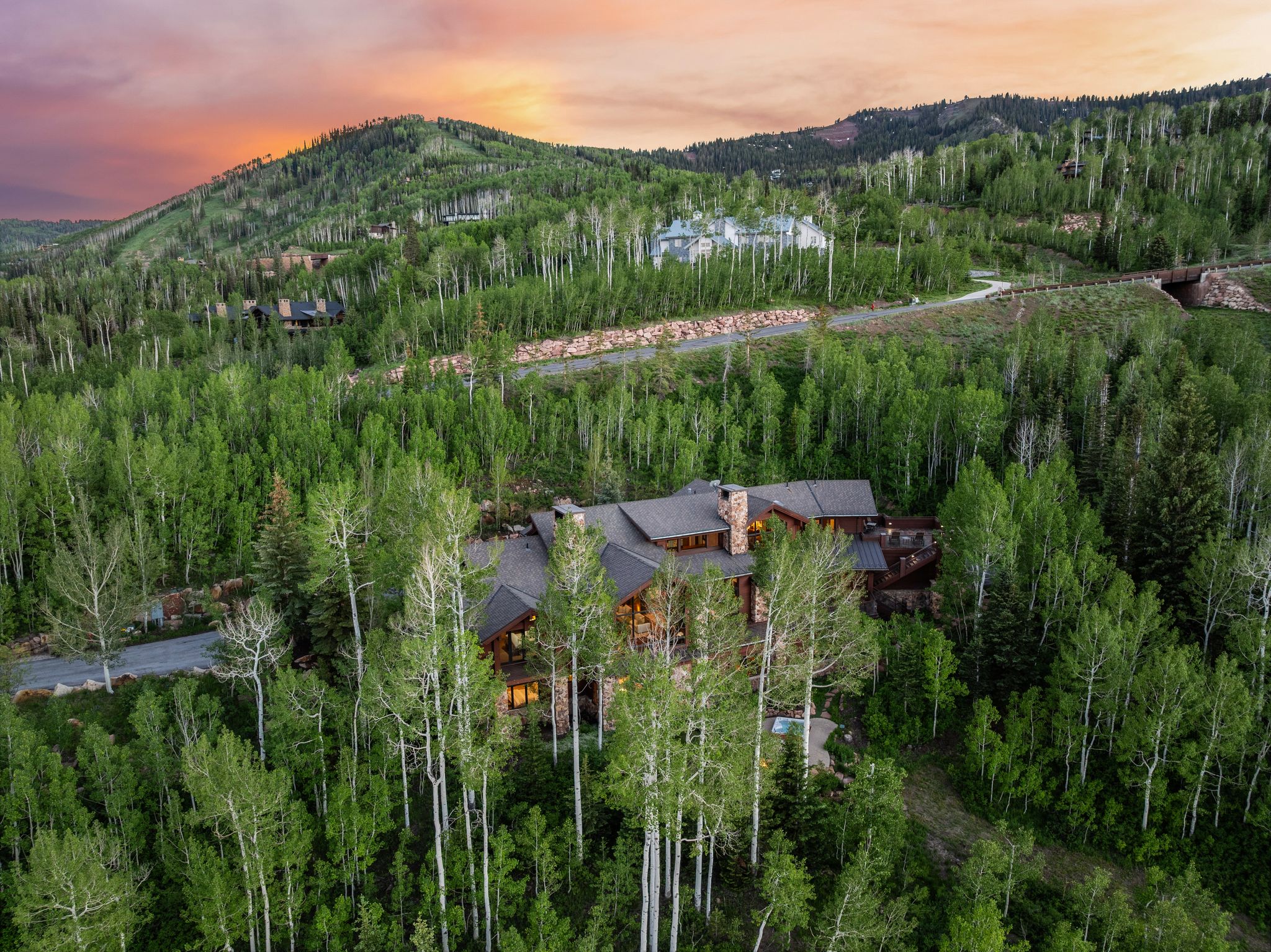 Mountain estate featuring a stone and wood-clad exterior, multiple gabled rooflines, and prominent stone chimney
