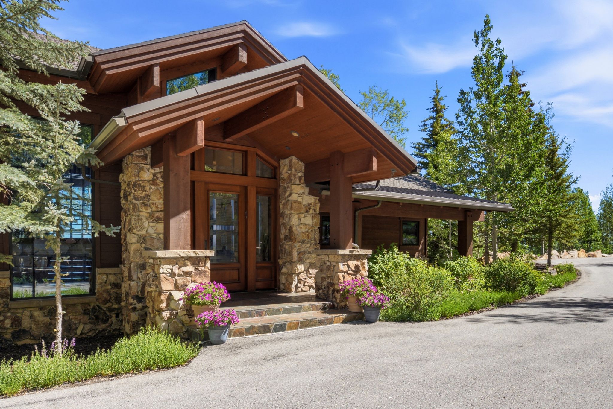 Front entrance featuring a stone facade and a wood-finish double door