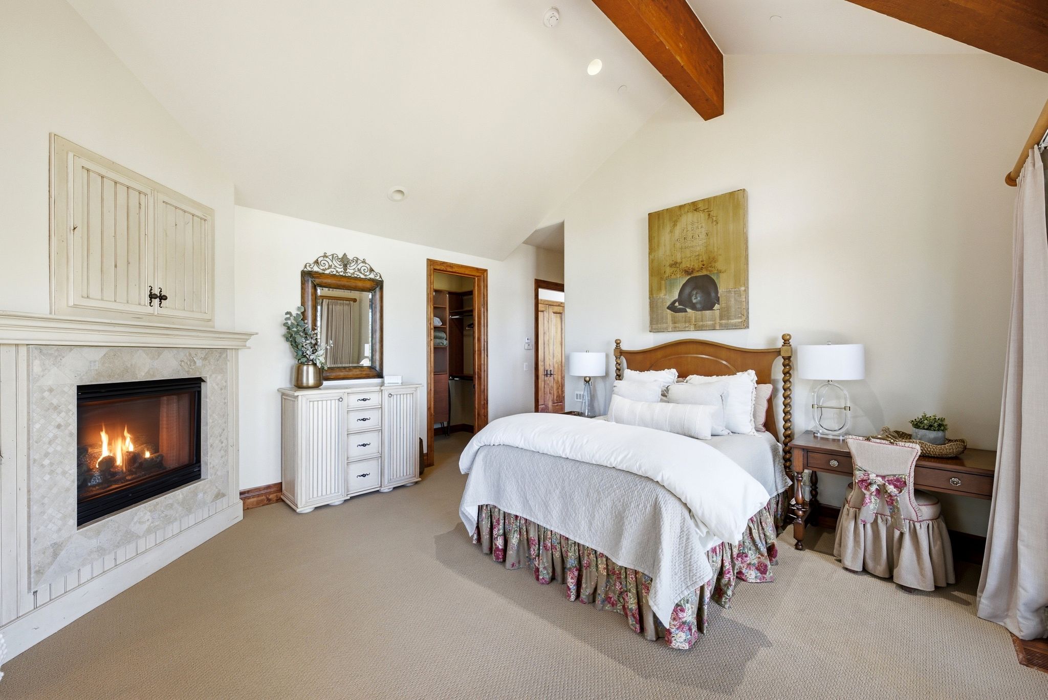 Carpeted room featuring a tiled fireplace with mantel, vaulted ceiling with exposed wood beams, and recessed lighting