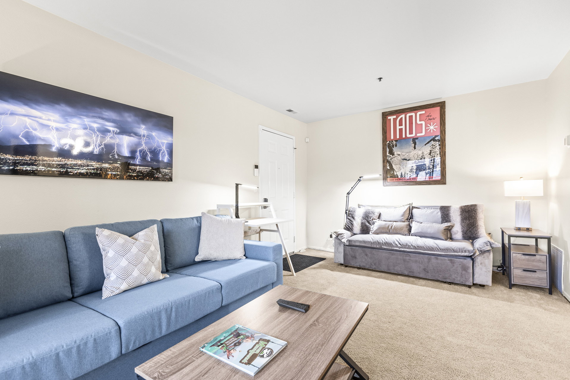 Open-concept living space featuring neutral-toned carpeting and light-colored walls