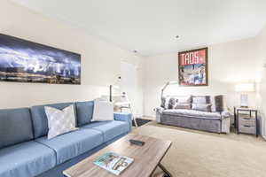 Open-concept living space featuring neutral-toned carpeting and light-colored walls
