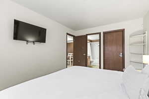 White walls with a mounted television and wood-finish doors