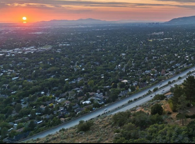 Expansive aerial perspective showcasing a widespread residential area and a prominent multi-lane highway