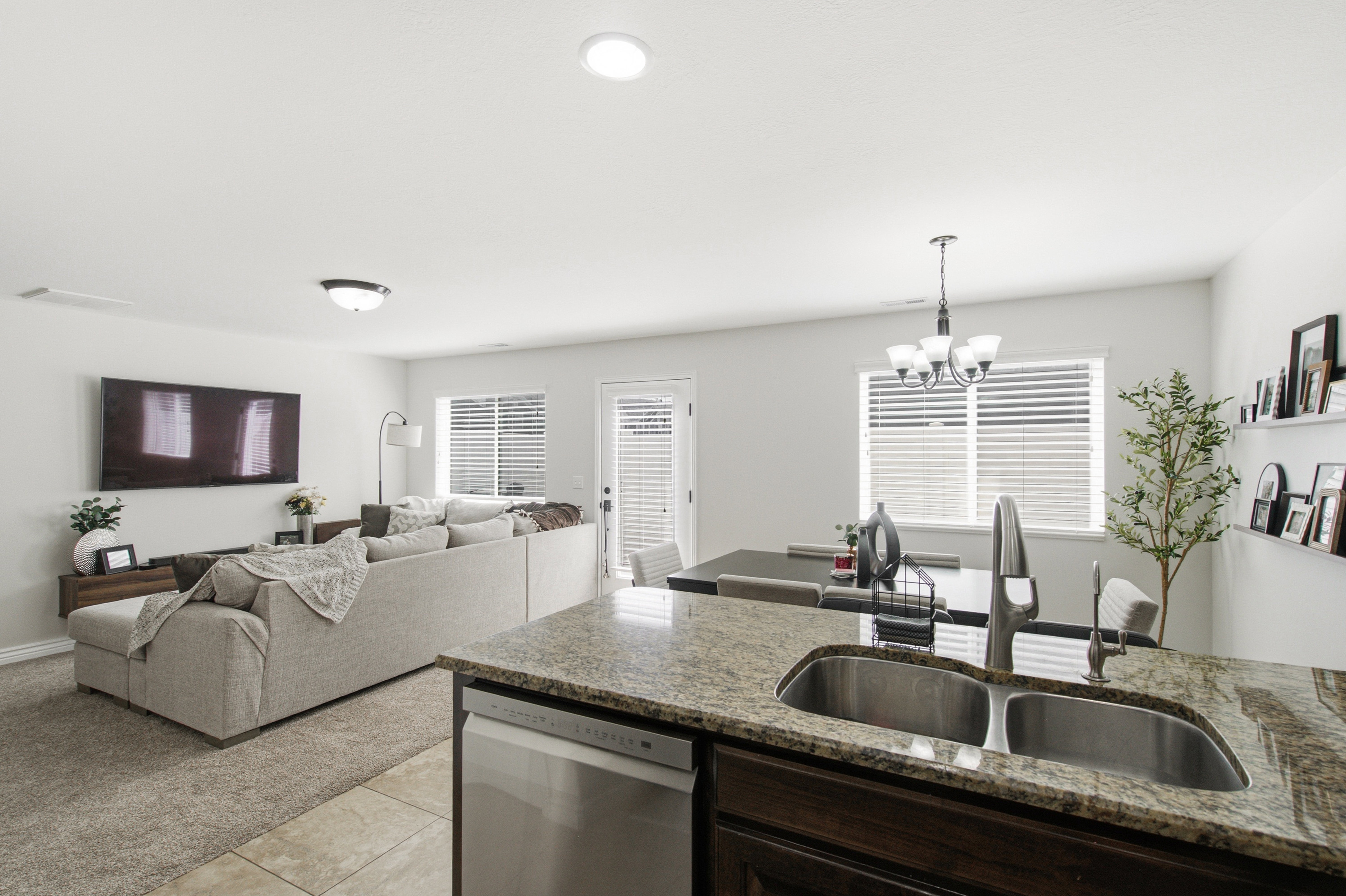 Kitchen island featuring a dual basin stainless steel sink, a chrome faucet, and a light-toned countertop