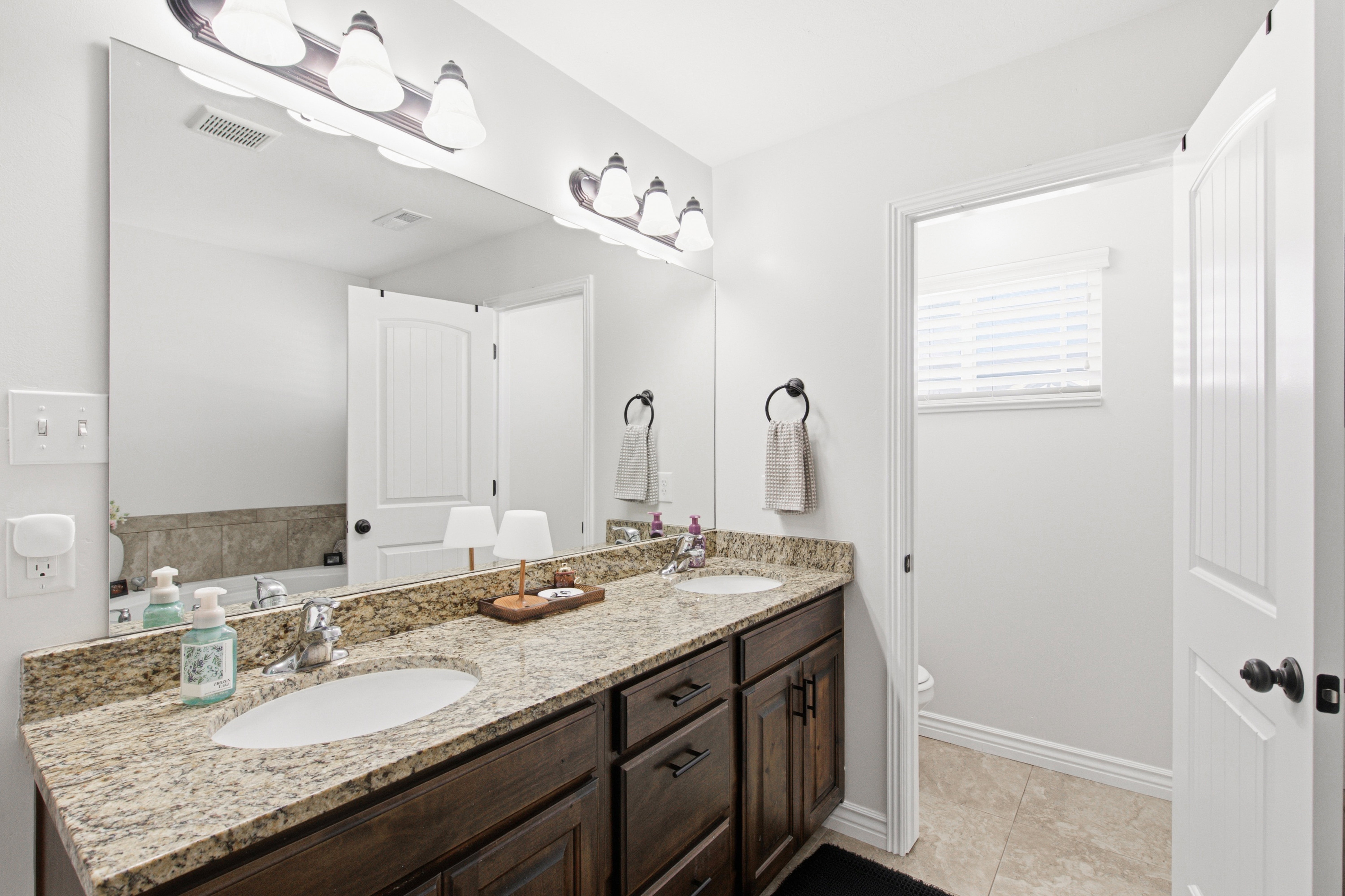 Dual vanity with a stone countertop and integrated sinks
