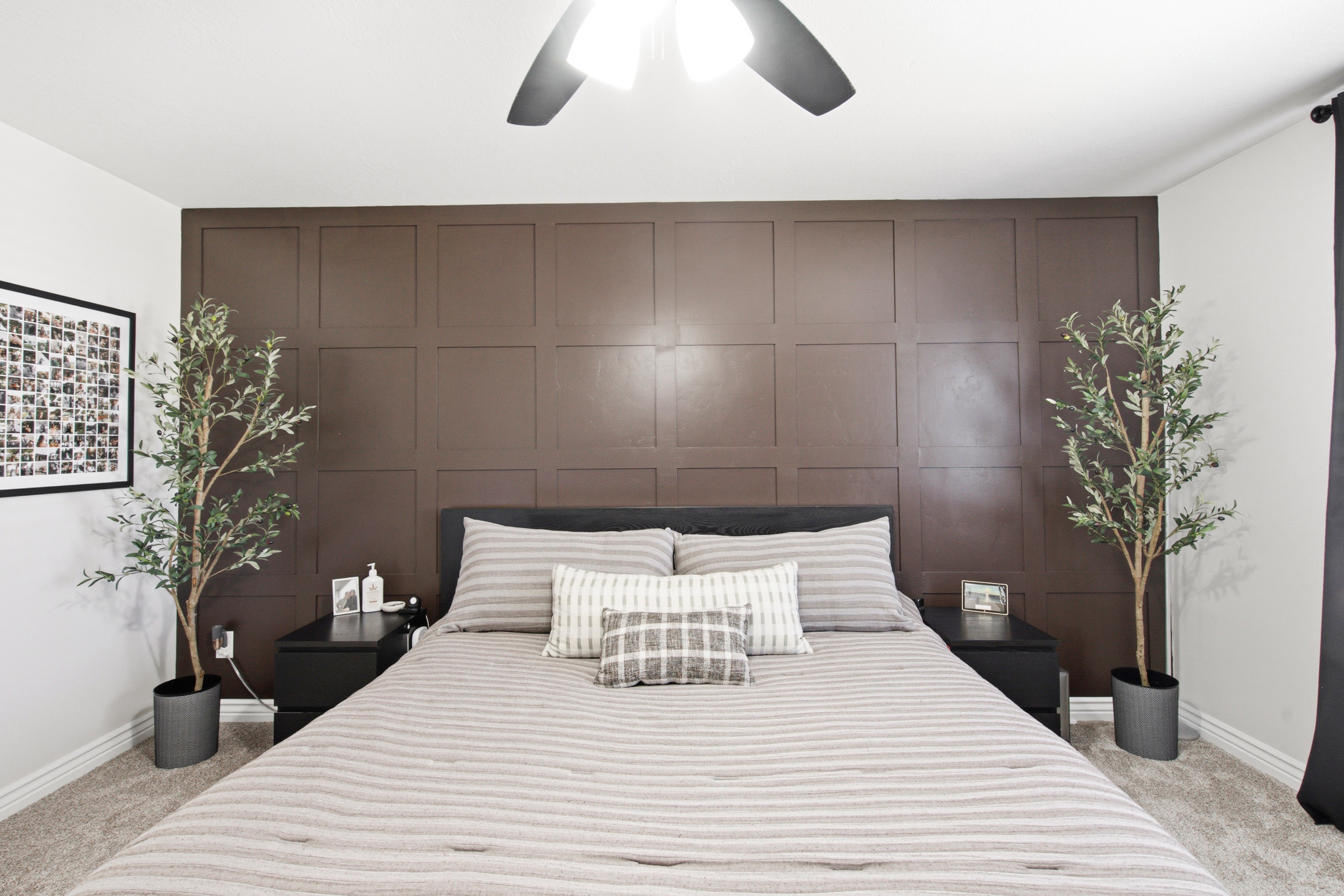 Wall-to-wall carpeted bedroom featuring a paneled accent wall