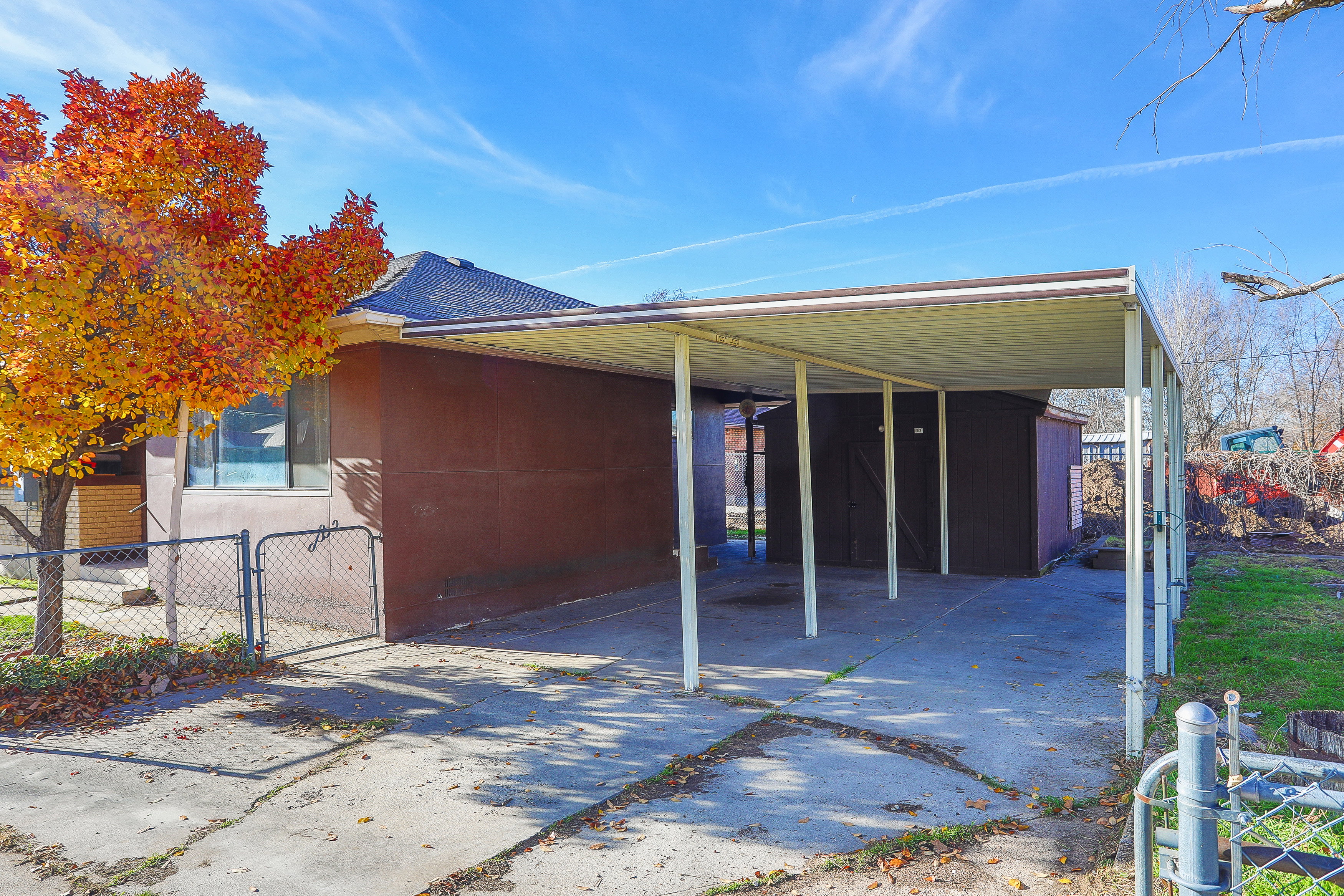 Concrete driveway with a covered carport offering sheltered parking