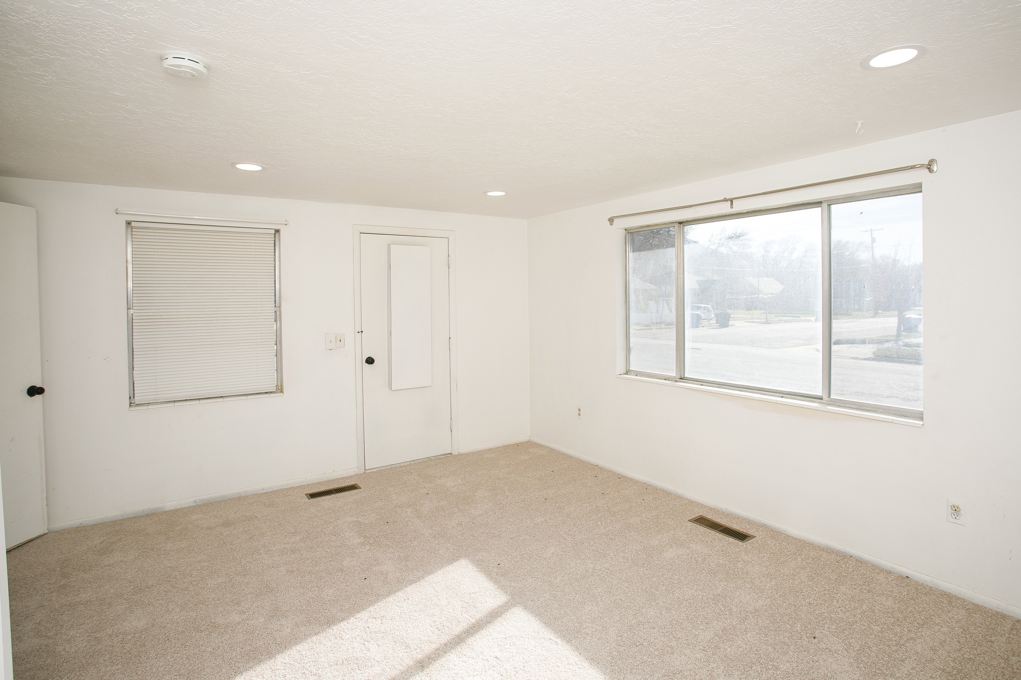 Carpeted room with recessed lighting and multiple windows