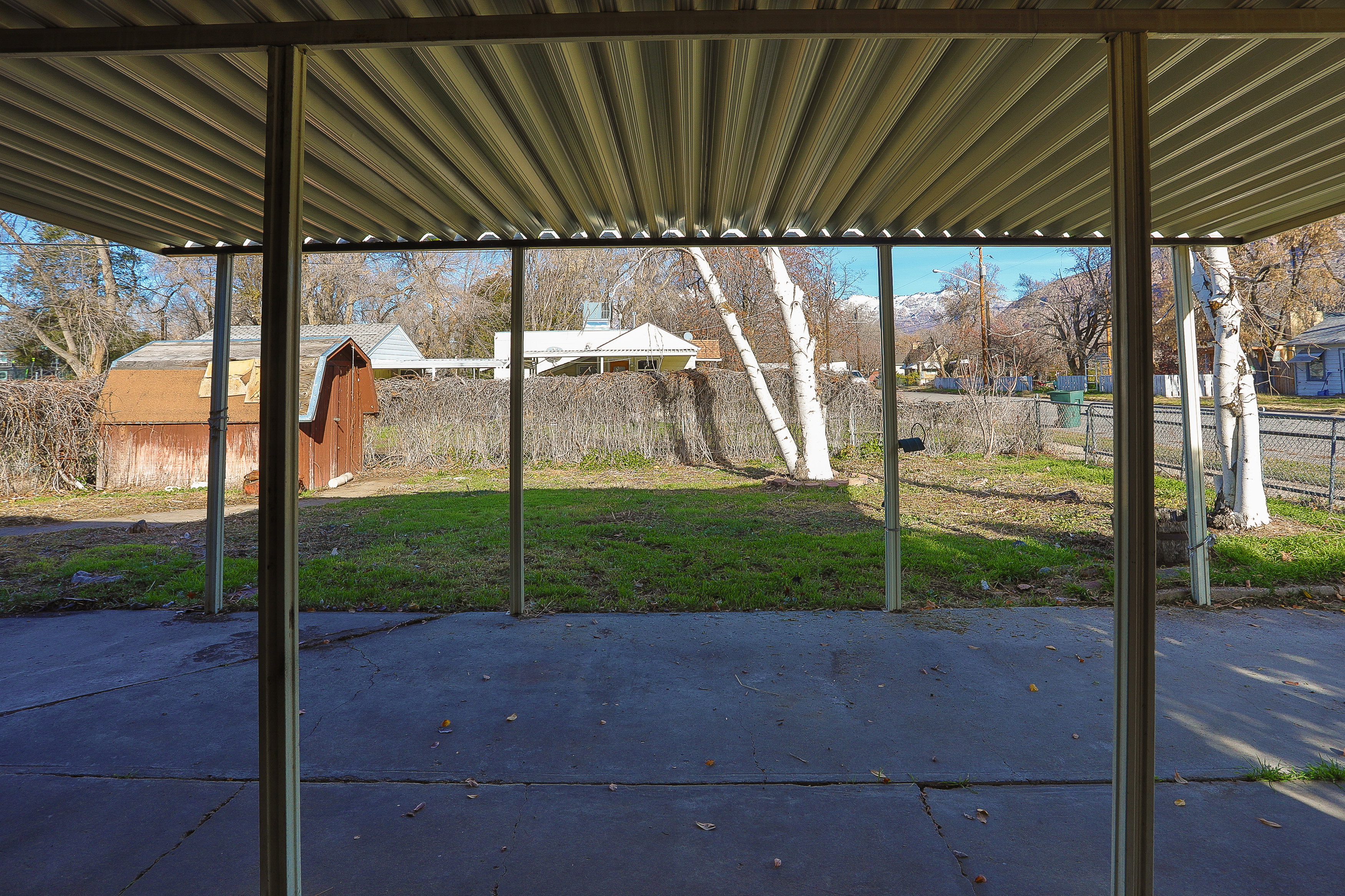 Covered patio space featuring a corrugated metal roof and concrete flooring