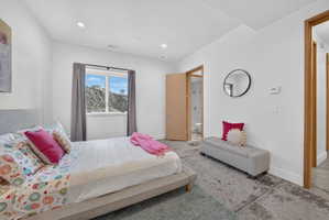 Bright room featuring a window with a mountain backdrop, recessed lighting, and a light wood-finish door frame