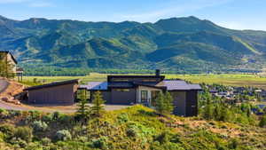 Contemporary architectural design featuring a dark-toned exterior, multiple rooflines, and a prominent chimney