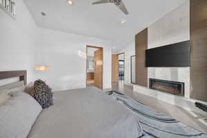 Contemporary room featuring a floor-to-ceiling accent wall with a linear fireplace, wall-mounted television, and wood-finish paneling
