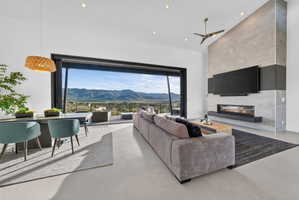 Expansive living area with large format sliding glass doors opening to a mountainous landscape