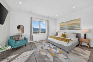 Bright bedroom featuring a large window with mountain scenery, recessed lighting, and durable flooring