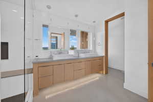 Contemporary bathroom featuring a light wood-finish double vanity with dual vessel sinks and pendant lighting