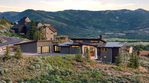 Contemporary architectural residence with dark siding, a metal roof, and large windows