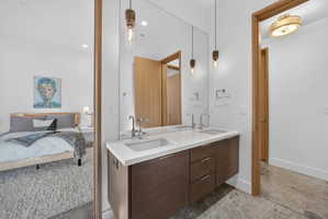 Double vanity with white countertop, chrome fixtures, and dark wood-finish cabinetry