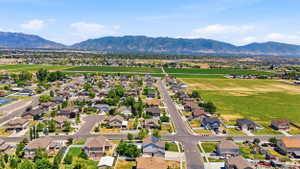 Aerial perspective showcasing a residential development with surrounding green fields and distant mountains