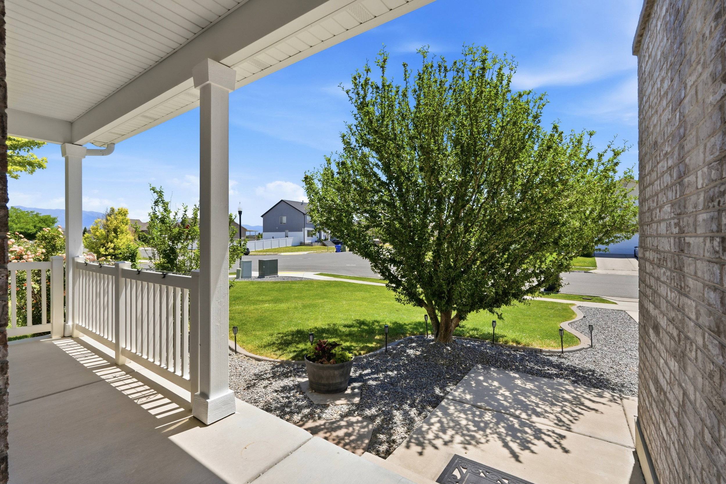 Covered front porch with white railings and columns