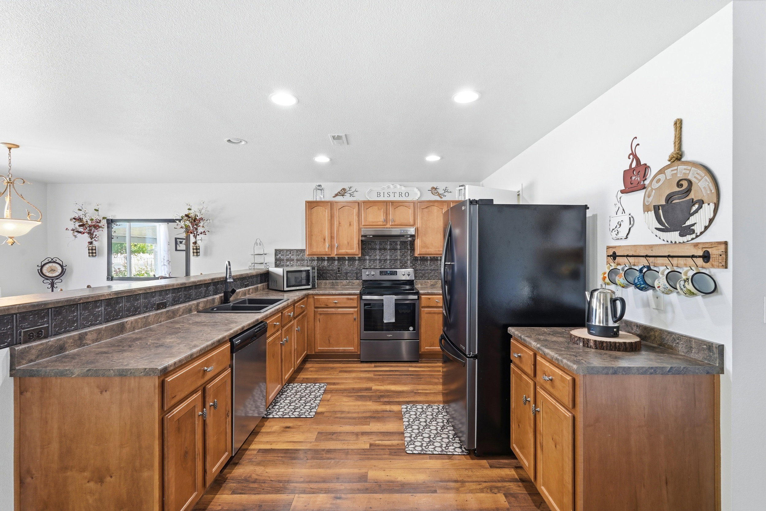 Kitchen featuring wood-finish flooring, recessed lighting, and a black appliance suite
