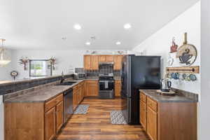 Kitchen featuring wood-finish flooring, recessed lighting, and a black appliance suite