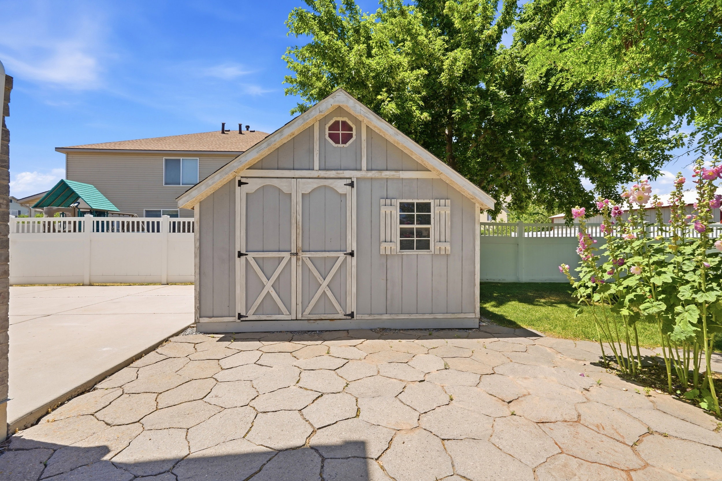 Gable-roof storage shed featuring board and batten siding with decorative double doors