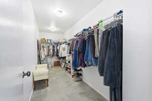 Spacious walk-in closet featuring light-toned tile flooring, built-in wire shelving, and recessed lighting fixtures