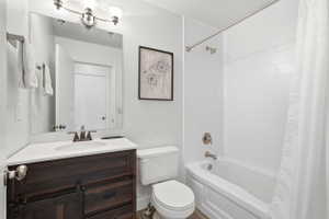 Bathroom featuring a wood-finish vanity with a white countertop, an undermount sink, and a bronze-finish faucet