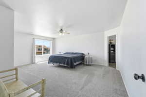 Spacious bedroom featuring light gray carpeting and a ceiling fan