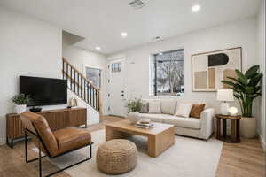 Bright living space featuring wood-finish flooring, recessed lighting, and a prominent window