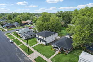 Aerial perspective showcasing a residential street with manicured lawns and mature trees