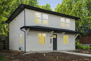 Two-story residence featuring white horizontal siding and a dark shingle roof